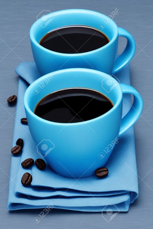 due tazze di caffè con tovagliolo blu