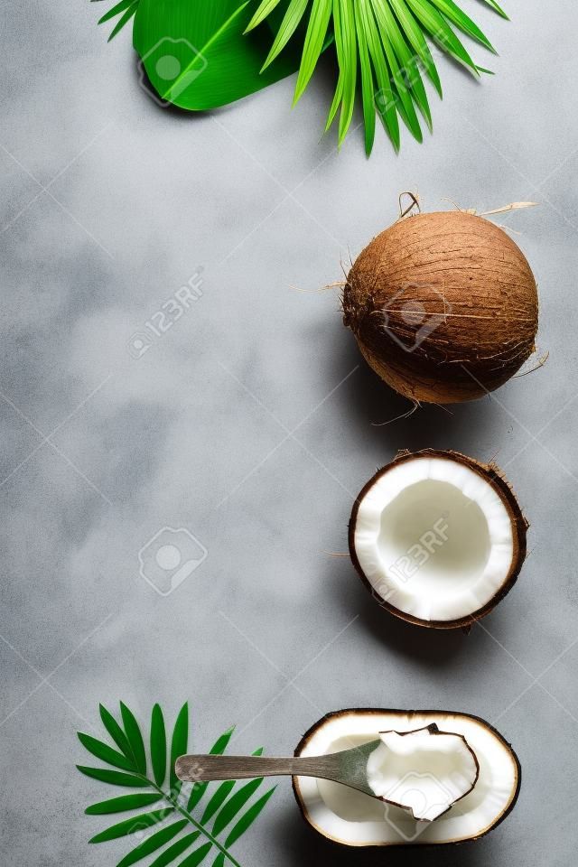 Coconut oil, tropical leaves and fresh coconuts