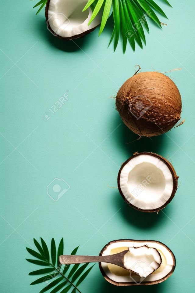 Coconut oil, tropical leaves and fresh coconuts