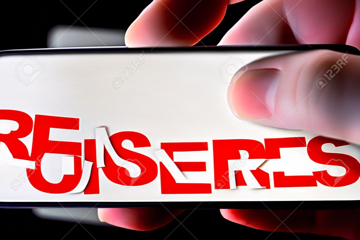 A smartphone lying on a table in the dark, displaying "censored" text. The finger above touch screen. The concept of censorship on popular social networks. Restricted access to internet. Shallow DOF