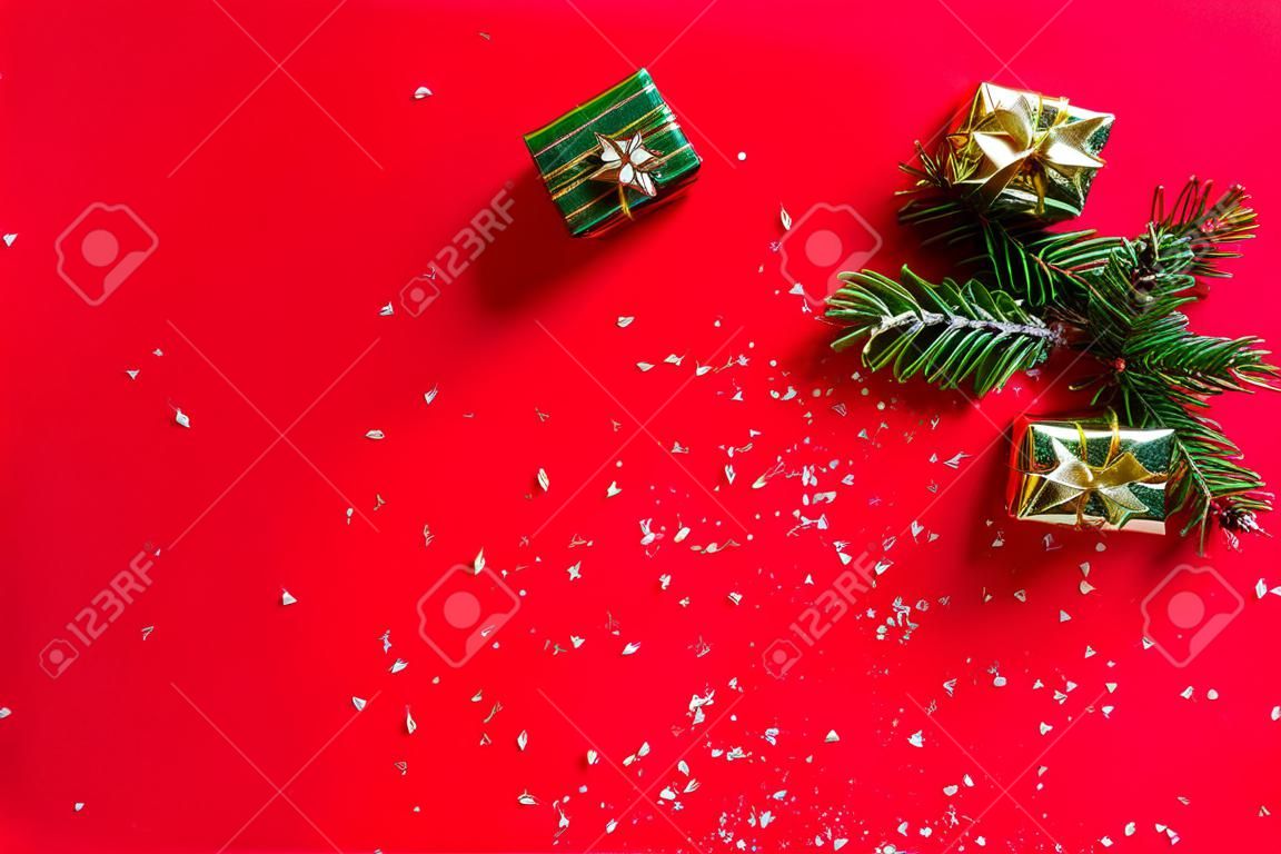 Weihnachtskomposition. Neujahr. Geschenke, Tannenzweige, roter Hintergrund. Weihnachten, Winter, Neujahrskonzept. Flache Lage, Draufsicht, Kopierbereich.