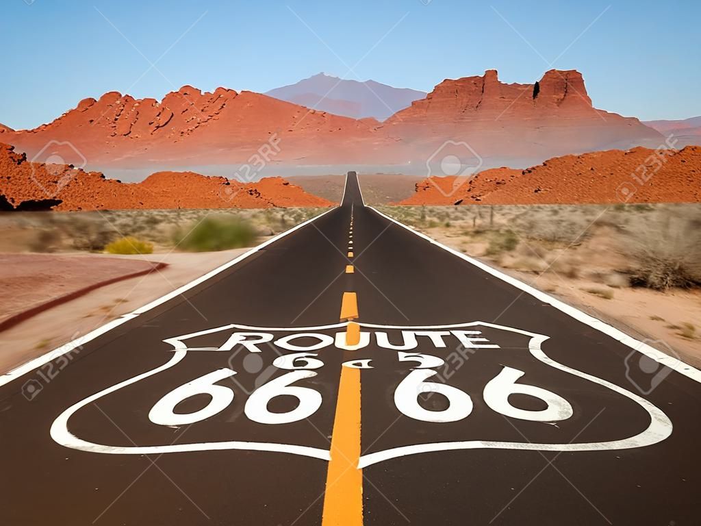 Ruta 66 signo pavimento con las montañas del desierto de Mojave de roca roja.