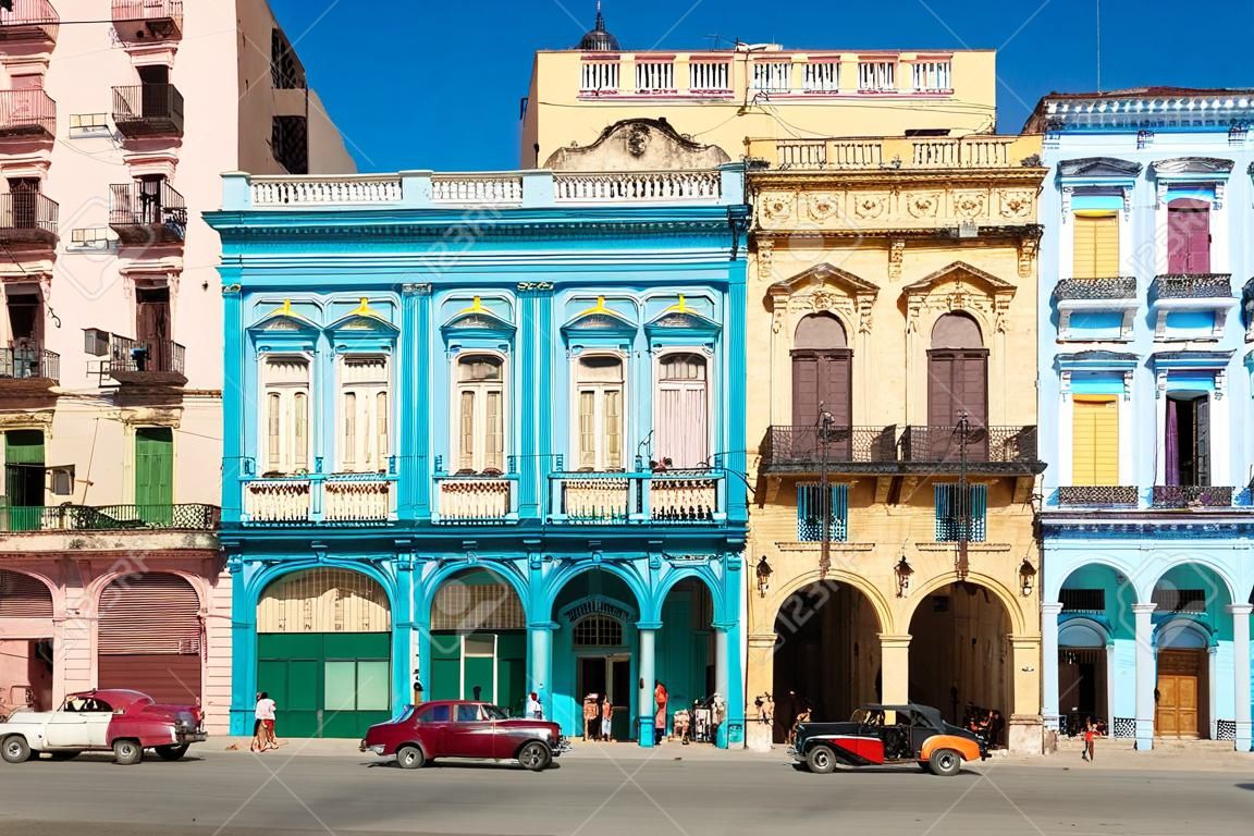 Street scene with old cars and colorful buildings in downtown Havana