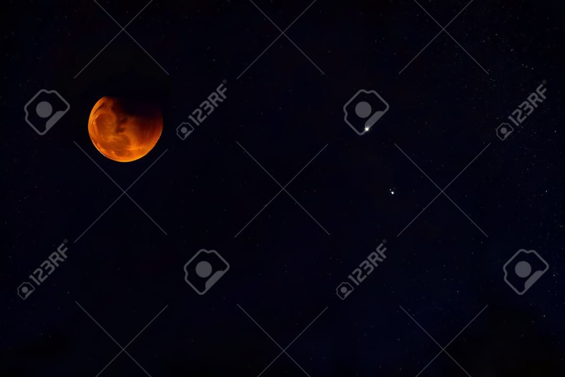 주황색 달은 밤에 별이 빛나는 하늘을 배경으로 하는 자연 위성인 초승달을 왁싱하고 있습니다