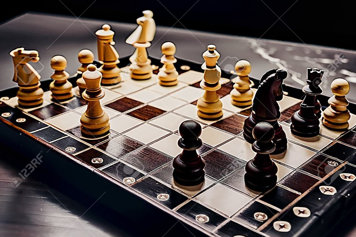 Old vintage chess pieces on wooden chessboard. Board strategy game. Teamwork, success business, intelligence sport concept.