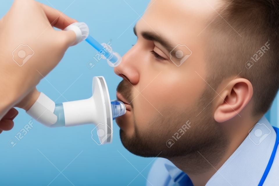 Young man testing breathing function by spirometry