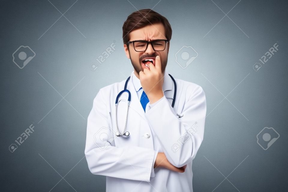 Médico masculino inseguro mordendo as unhas parecendo engraçado com medo desejando algo ansioso.