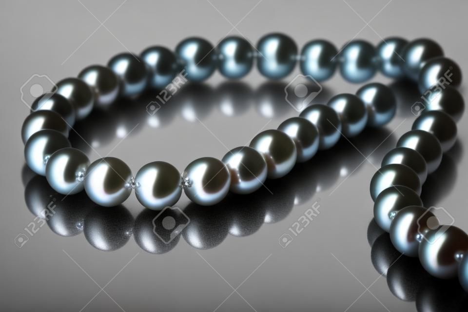 pearl necklace on a black background with reflection