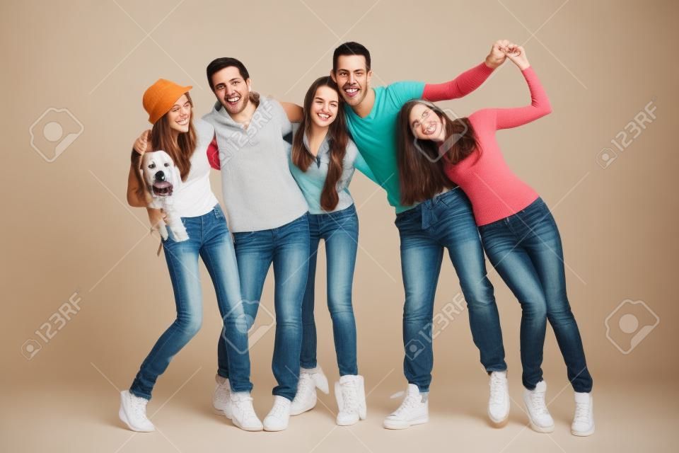 Smiling group of young friends with dog