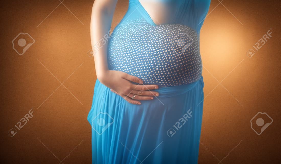 Foto präsentiert den Bauch der schwangeren Frau