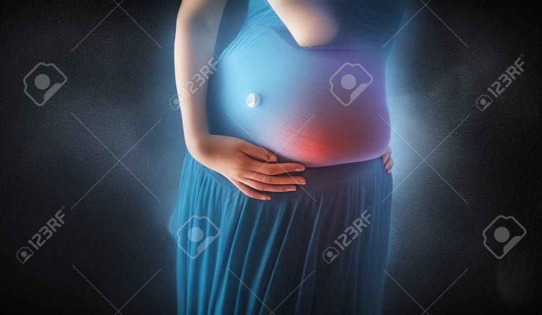 Foto präsentiert den Bauch der schwangeren Frau