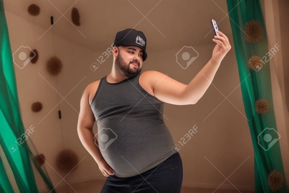 Retrato engraçado de um cara gordo tomando uma selfie
