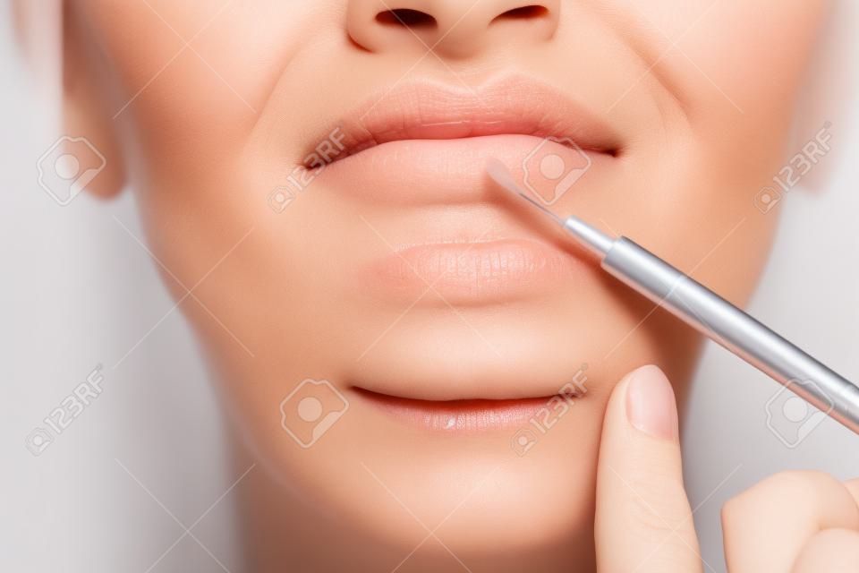 Mujer madura haciendo inyección cosmética para labios