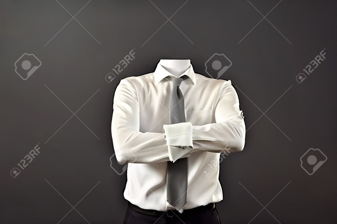 invisible man standing with folded arms over his chest against grey background