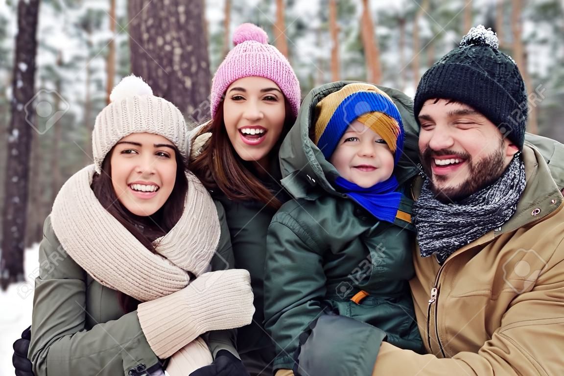 Close-up of funny happy family in the wintry woods. Having fun on a cold winter day. Spending time with a family. Smiling and laughing, the concept of togetherness and happiness 