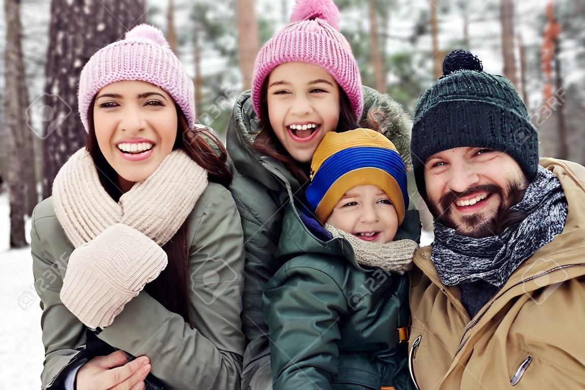 Close-up of funny happy family in the wintry woods. Having fun on a cold winter day. Spending time with a family. Smiling and laughing, the concept of togetherness and happiness 