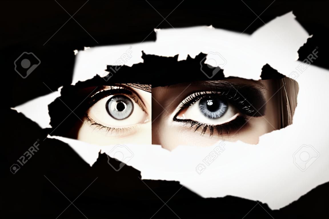 Women's blue eyes spying through a hole