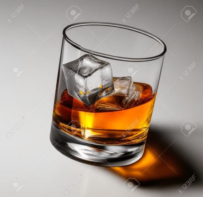 Bicchiere di scotch whisky e ghiaccio su sfondo bianco