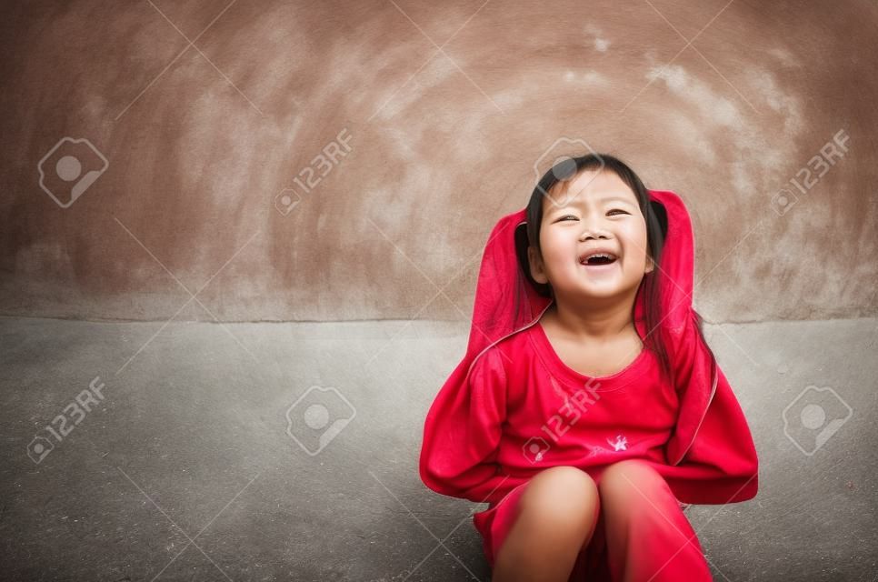Asian child cute or kid girl sit stomachache and sick from bacteria and gastritis with diarrhea or hungry with holding hand in stomach to frown and poor on street with space