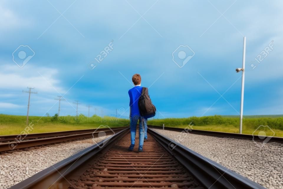 Niño adolescente con problema caminando en ferrocarril