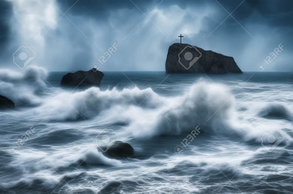 Tempesta di mare con belle onde. Vista sul mare con una pietra. Croce cristiana sulla scogliera. Giornata nuvolosa, il maltempo. Crimea