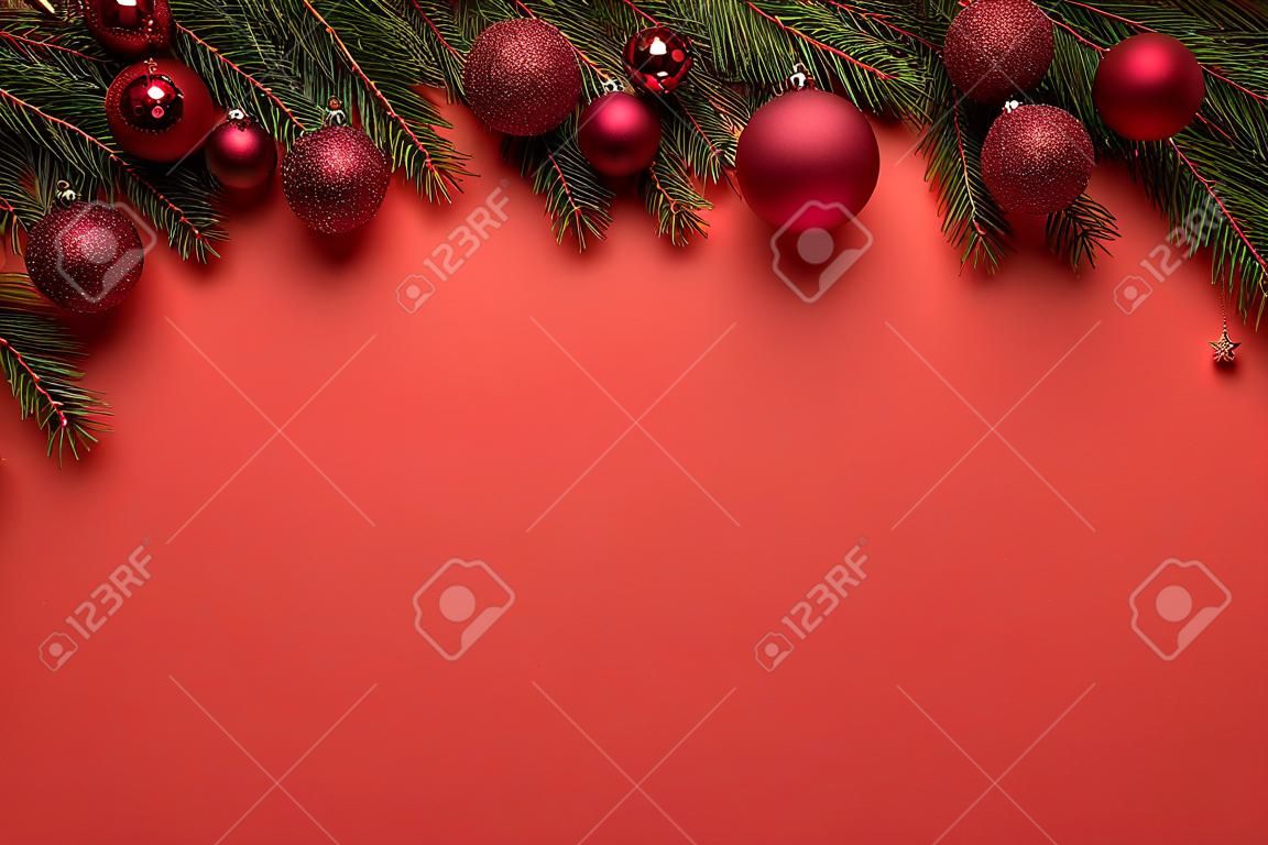 Sfondo rosso con palline di Natale e rami di abete. Decorazione di buon Natale o Capodanno con spazio di copia