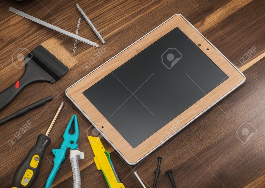 Verschillende apparatuur gereedschappen van bouwer en tablet pc op houten textuur tafel