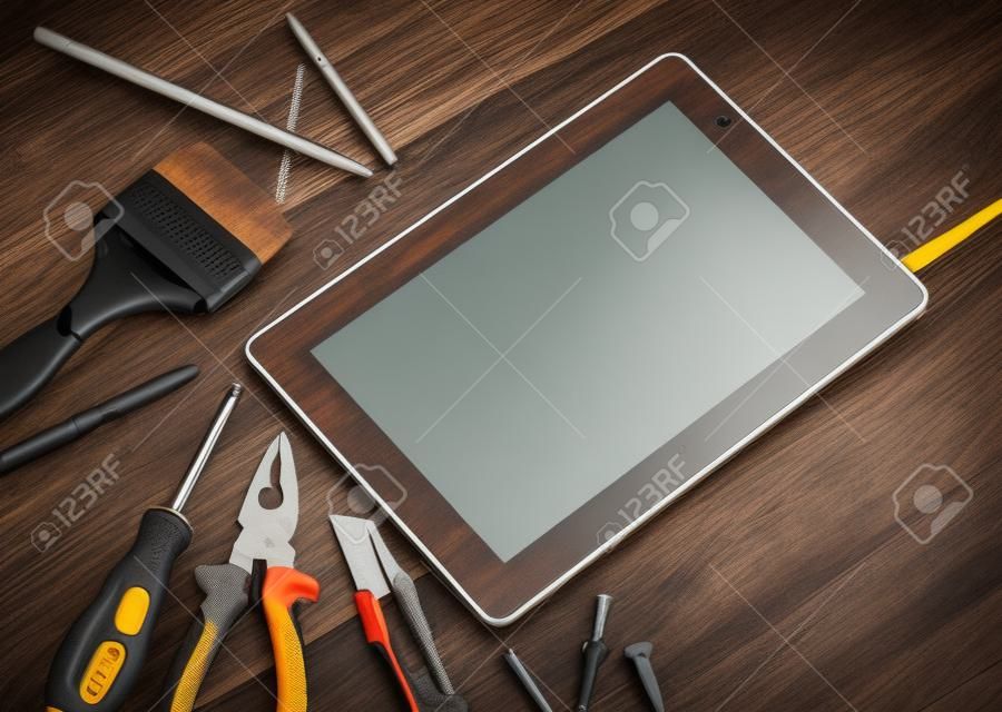 Verschillende apparatuur gereedschappen van bouwer en tablet pc op houten textuur tafel