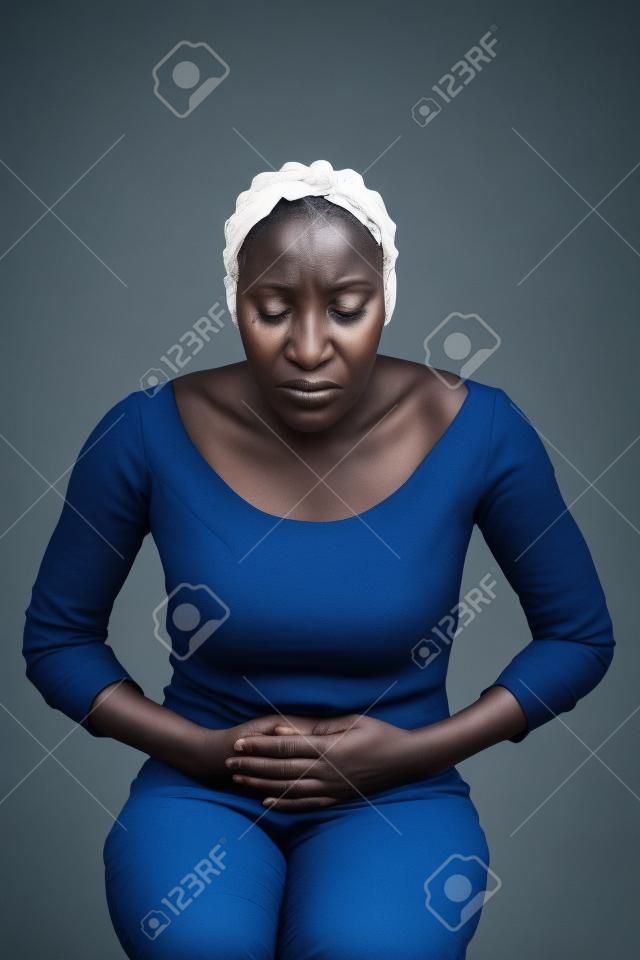 Facade shot of an African woman suffering from abdominal pain