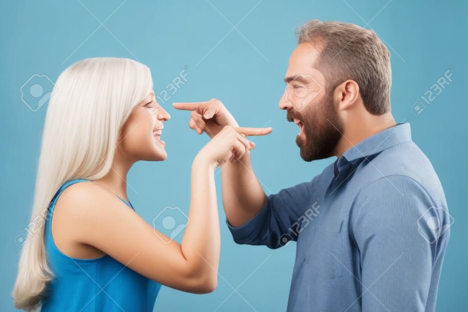 Imagen horizontal de un par apuntando con un dedo el uno del otro