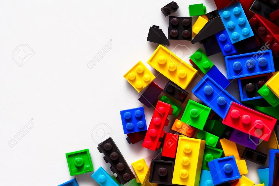 Close-up immagine di mattoncini lego colorati sparsi sul fianco di uno sfondo bianco