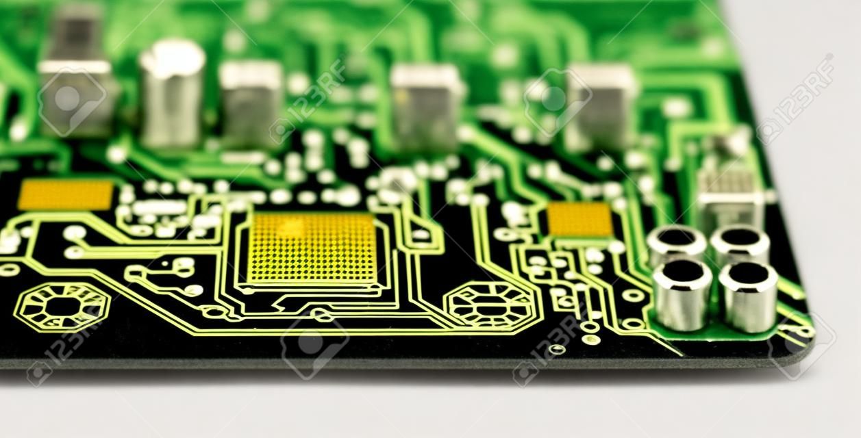 Printed circuit board on modern computer motherboard detail with electronic components. Micro chips, capacitors or resistors and yellow LED light effects on black background. Surface-mount technology.