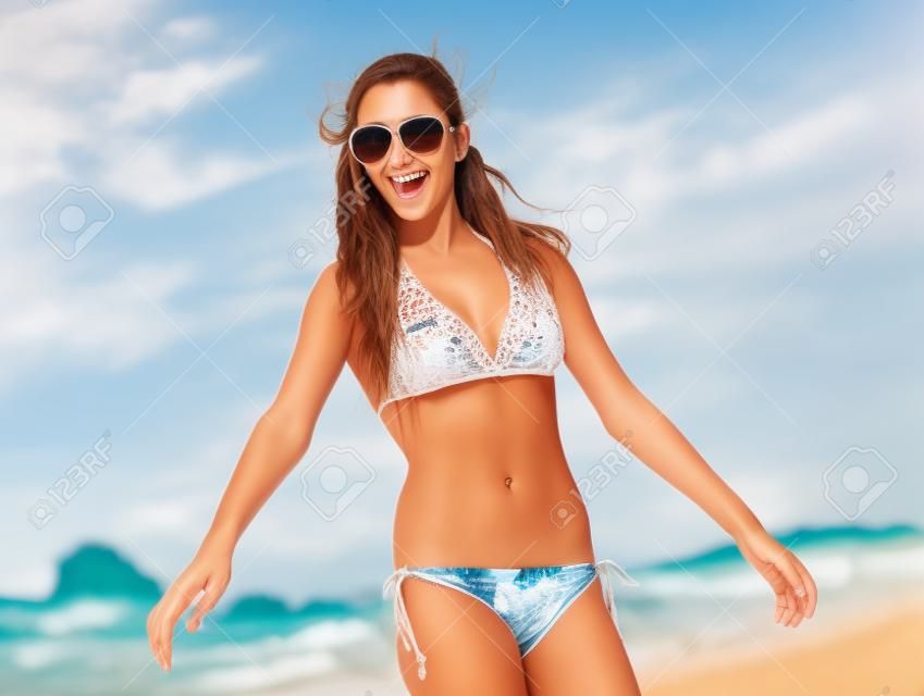 Piękna młoda kobieta spacerująca po plaży ze spokojnym i szczęśliwym wyrazem twarzy