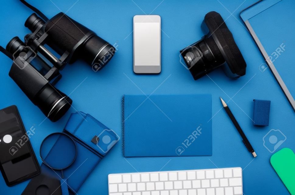 Flat lay of accessories on blue desk background of photographer, Voyage concept.