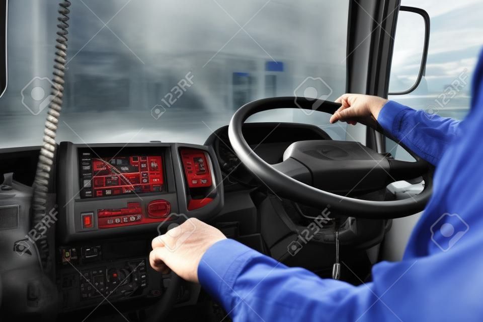 O motorista do caminhão continua dirigindo com uma mão e muda de marcha, o homem atrás do volante do caminhão semi, foco do ponto.