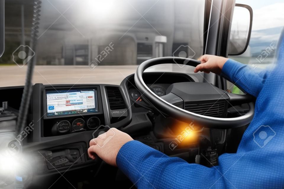 El conductor del camión sigue conduciendo con una mano y cambia de marcha, el hombre detrás del volante del camión, enfoque en el punto.