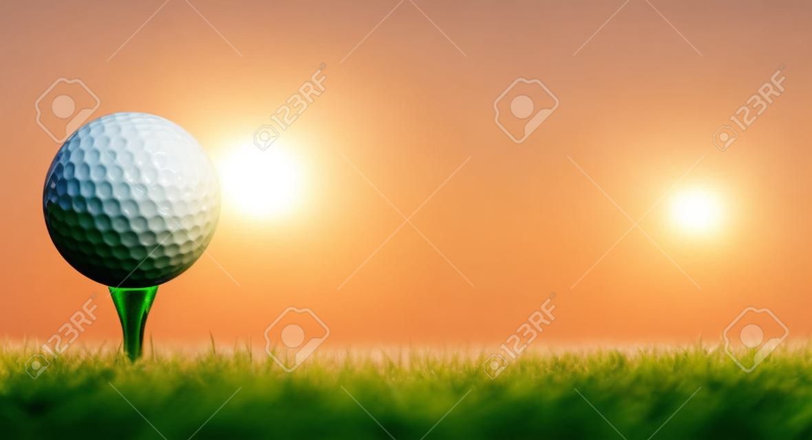 Мяч для гольфа на ее тройника в зеленой травой поле для гольфа с восхода солнца.
