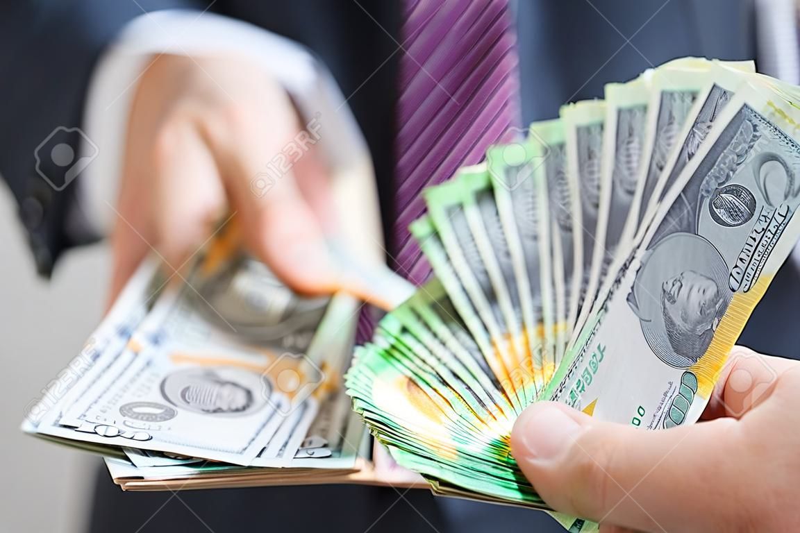 貨幣兌換和交易的概念 - 手拿著澳元（AUD）的商人拿著美國美元（USD）票據模糊背景鈔票，大約交換