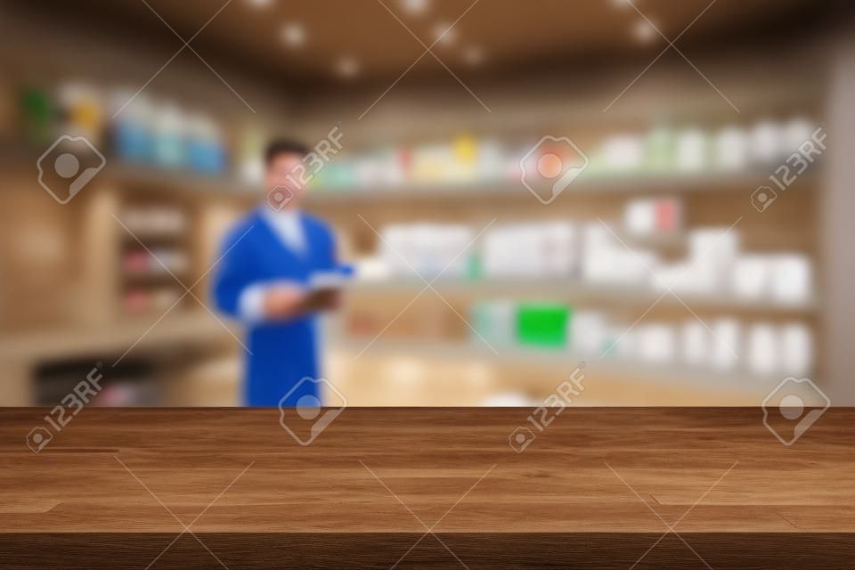 Empty wood counter top on blur pharmacy (chemist shop or drugstore) background
