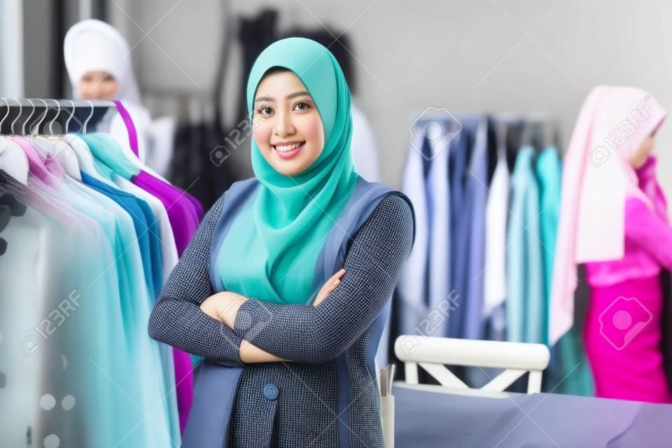 Designer de femme musulmane asiatique en tant que propriétaire d'une entreprise de démarrage dans sa boutique de tailleur