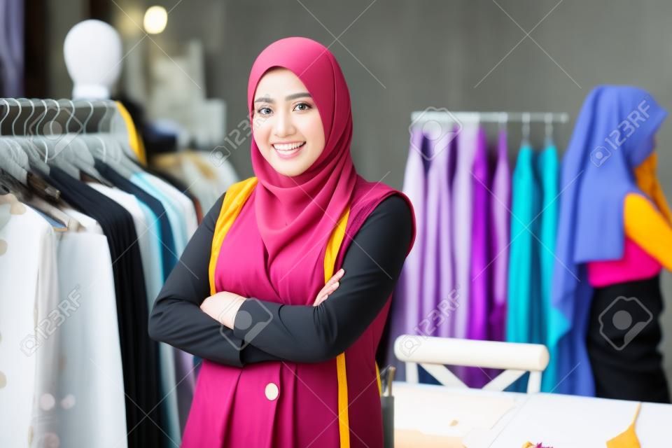 Diseñador de mujer musulmana asiática como propietario de un negocio de inicio en su sastrería