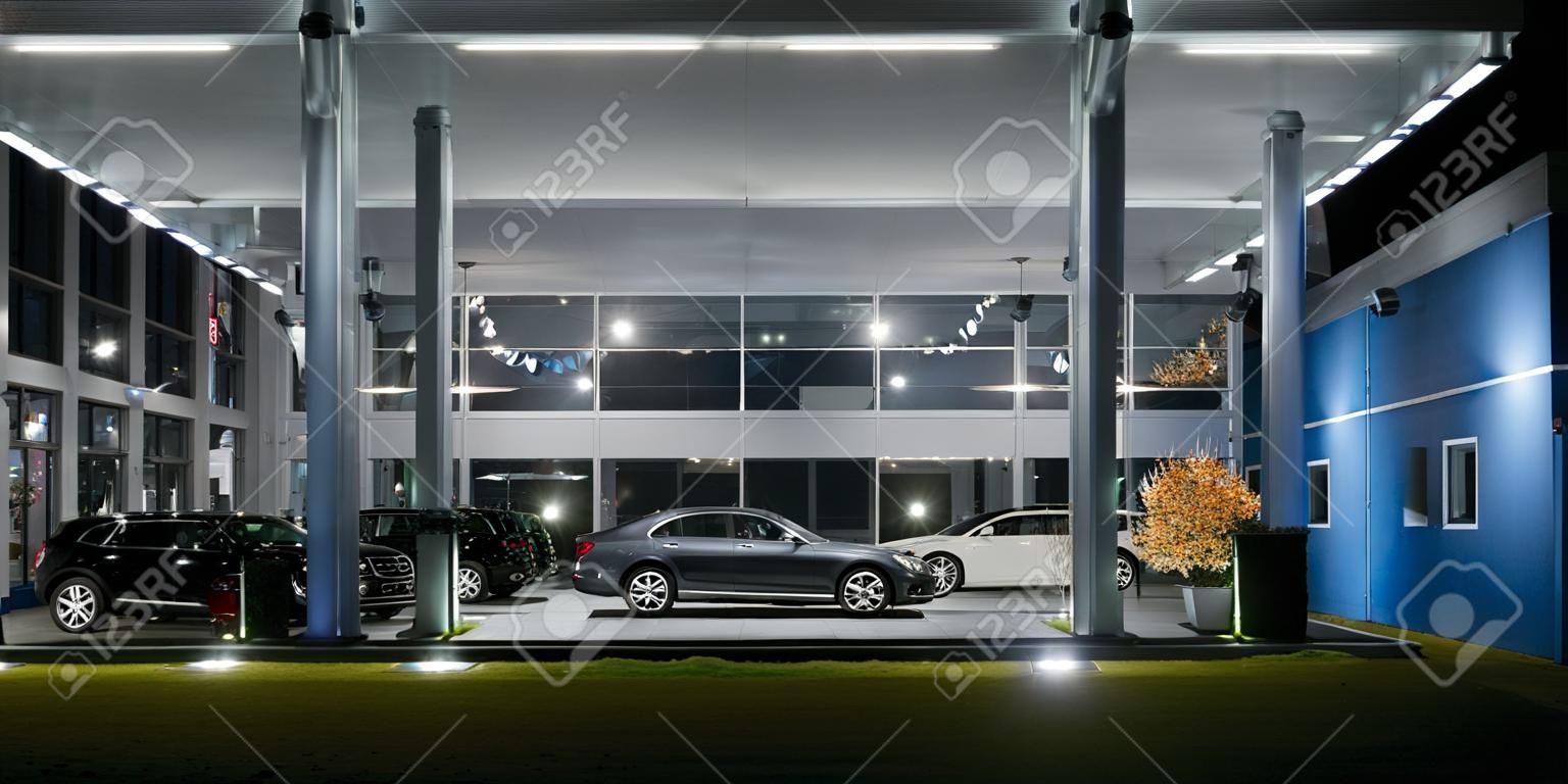 Modern bir araba salonunun dış cephesi, gece çekimi.