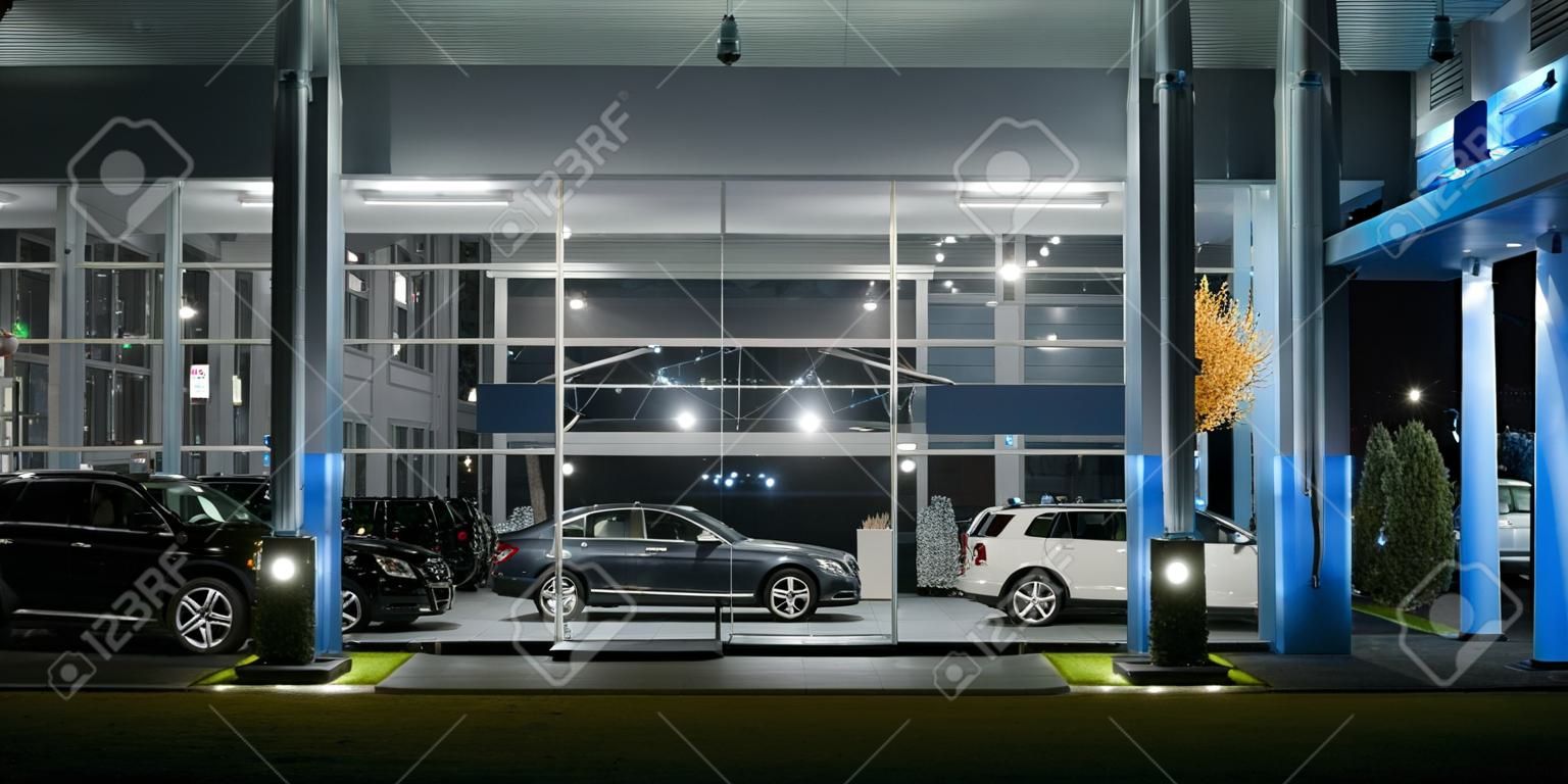 Modern bir araba salonunun dış cephesi, gece çekimi.