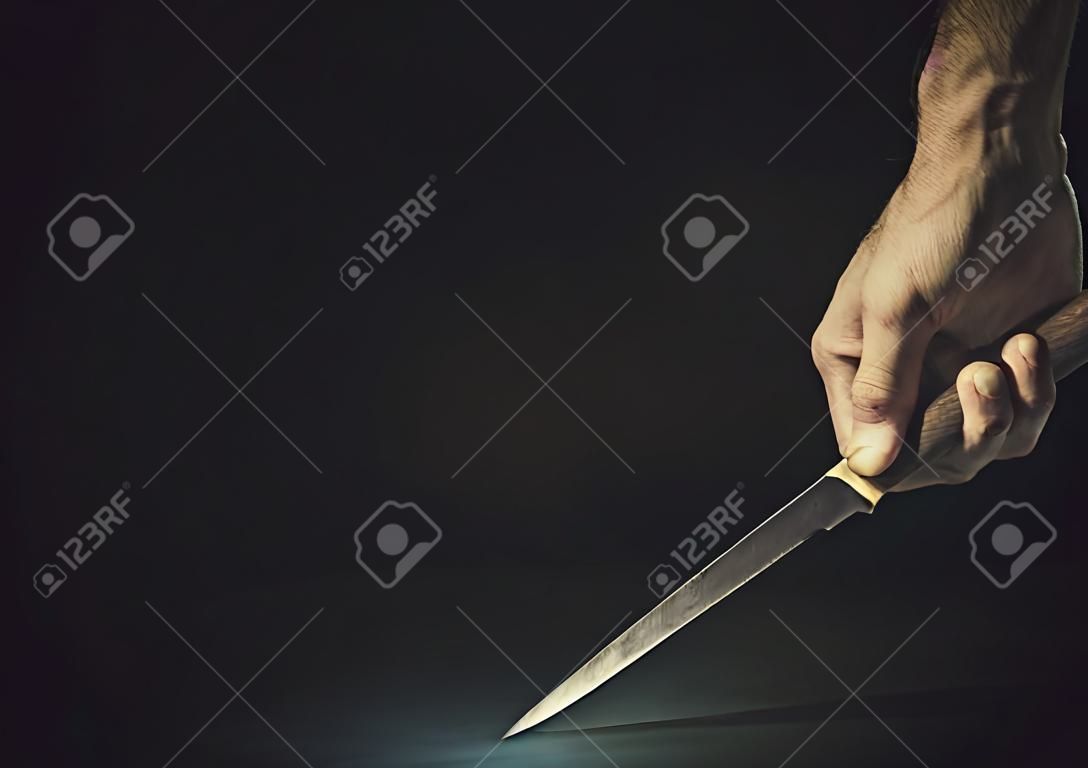 Conceptual composition of a dangerous situation, somebody is holding a knife.