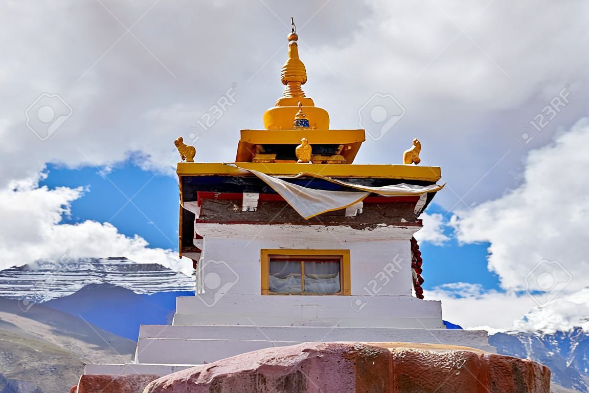 A small Tibetan monastery in the mountains with Buddha figurines inside.