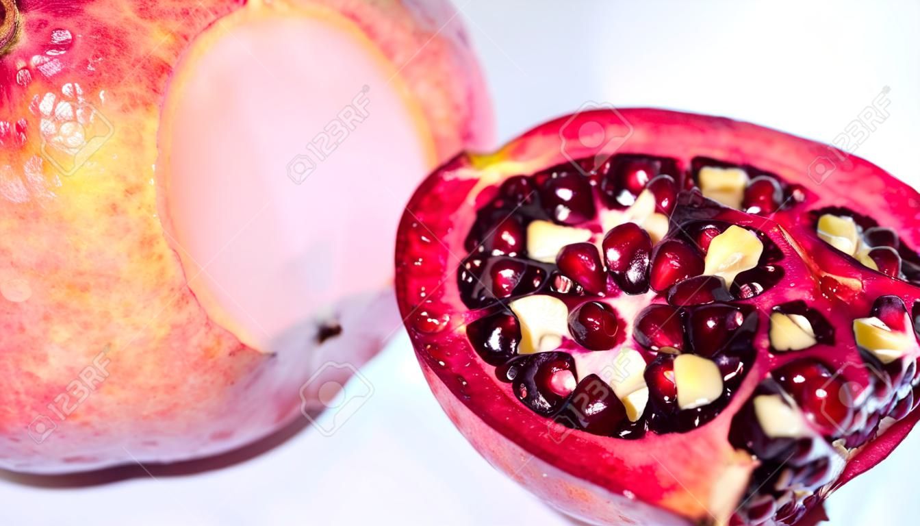 Juicy, fresh, ripe fruit on a light background. Pomegranate with a chopped top. Proper nutrition, freshly squeezed juices.