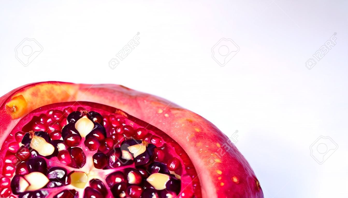 Juicy, fresh, ripe fruit on a light background. Pomegranate with a chopped top. Proper nutrition, freshly squeezed juices.