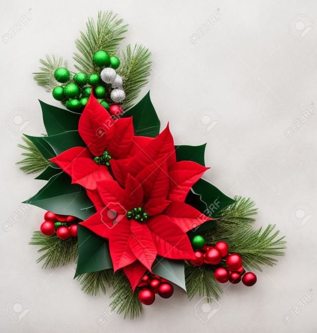 Christmas corner arrangement with pine twigs, red berries and poinsettia flowers isolated on white background. Flat lay. Top view.
