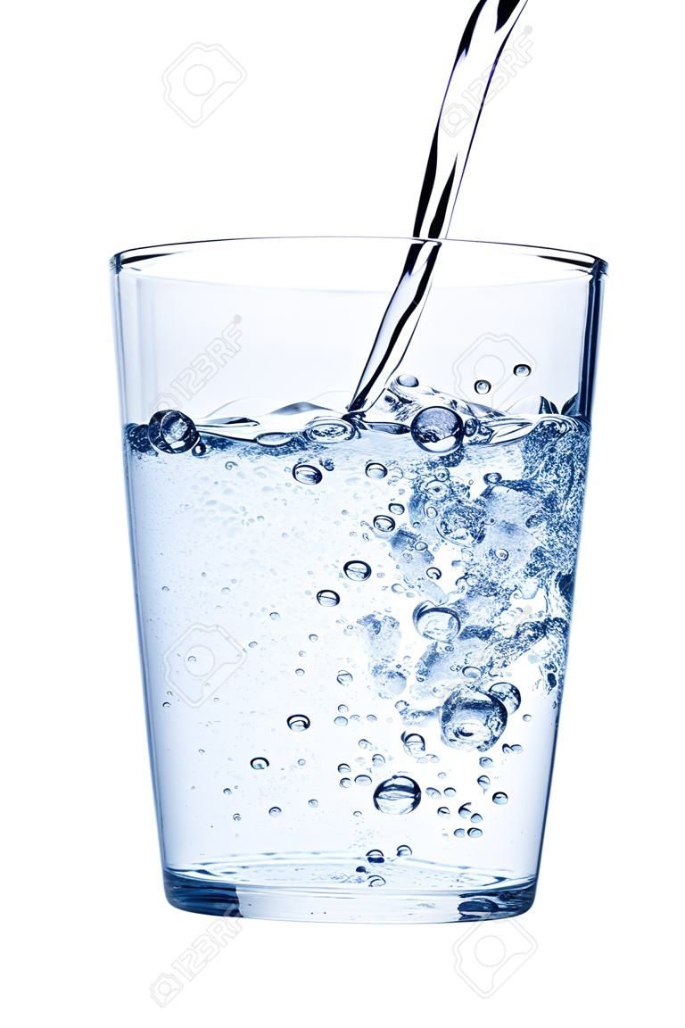 Wasser gießt in Glas auf weißem Hintergrund