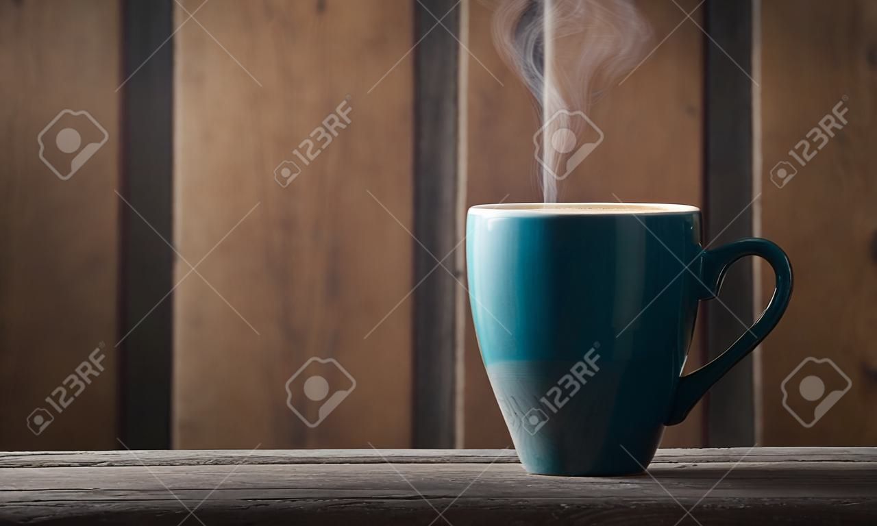 Coffee cup on wooden table in front of wooden wall.